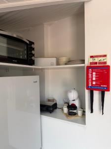 a microwave on top of a refrigerator in a kitchen at Meu Quintal 3, Calheta-Madeira in Calheta