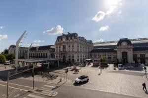 a car parked in front of a large building at Magnifiques Appartements - Face a la Gare in Bordeaux