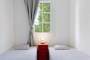 two twin beds in a room with a window at La Terrasse du Golf Bourgenay in Talmont +24 photos