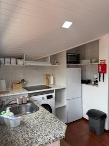 a kitchen with a sink and a white refrigerator at Meu Quintal 3, Calheta-Madeira in Calheta