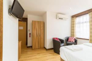 a room with a bed and a tv on a wall at Brick Lane Hotel in London