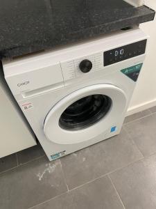 a white washing machine sitting under a counter at Private studio with a private bathroom and kitchenette in Edmonton
