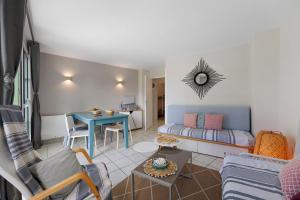 a living room with a couch and a table at La Terrasse du Golf Bourgenay in Talmont