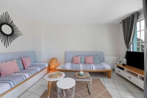 a living room with a couch and a tv at La Terrasse du Golf Bourgenay in Talmont