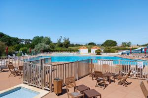 a large swimming pool with chairs and a deck with at La Terrasse du Golf Bourgenay in Talmont