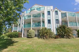 a large white building with blue balconies on it at La Terrasse du Golf Bourgenay in Talmont