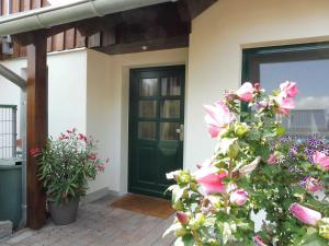 a front door of a house with pink flowers at Ferienwohnung Graf Knurrhahn in Karlshagen
