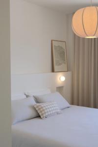 a bedroom with a white bed with a pillow at Apartment Maestral, Pucisca ,Island Brac in Pučišća