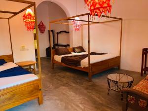 a bedroom with two bunk beds and a table at Paradise Bay Hotel in Arugam Bay