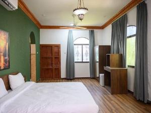 a bedroom with a white bed and green walls at Saal house in Nizwa