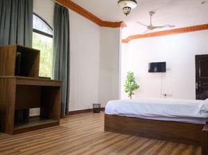 a bedroom with a large bed and a television at Saal house in Nizwa