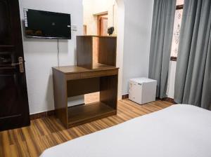 a bedroom with a bed and a tv on a wall at Saal house in Nizwa