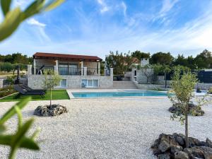 a home with a swimming pool and a house at Villa Maginja in Sutivan