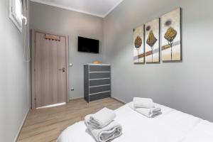 a bedroom with a bed and a tv on the wall at Deep Blue Escape Villa Salamina in Áyios Yeóryios +35 photos