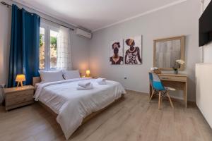 a white bedroom with a bed and a desk and a chair at Deep Blue Escape Villa Salamina in Áyios Yeóryios