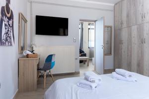 a bedroom with a bed and a desk and a tv at Deep Blue Escape Villa Salamina in Áyios Yeóryios