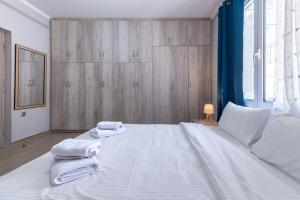 a bedroom with a large white bed with towels on it at Deep Blue Escape Villa Salamina in Áyios Yeóryios