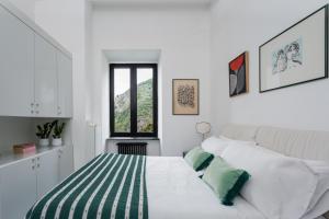 a white bedroom with a bed with green and white pillows at Villa Margi in Vico Equense +116 photos