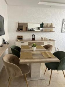 eine Küche mit einem Holztisch und grünen Stühlen in der Unterkunft infinity by Hadil-Rabat centre ville in Rabat + 22 Fotos