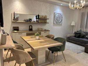 eine Küche und ein Wohnzimmer mit einem Holztisch und Stühlen in der Unterkunft infinity by Hadil-Rabat centre ville in Rabat