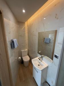a white bathroom with a sink and a toilet at Pensjonat Resident in Krynica Morska +24 photos