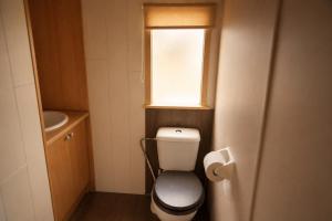 a small bathroom with a toilet and a window at Rustig Chalet Ardennen The Forest Haven in Amblève