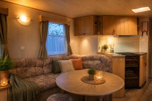 a living room with a couch and a table at Rustig Chalet Ardennen The Forest Haven in Amblève