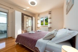 a bedroom with a bed with pillows and a window at Villa Balen ZadarVillas in Lisičići +42 photos