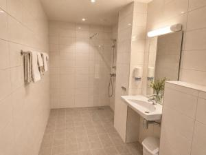 a white bathroom with a sink and a shower at Haukeland Hotell in Bergen