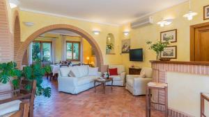 a living room with couches and a fireplace at PODERINA DEI POGGI 12, Emma Villas in Castiglione del Lago