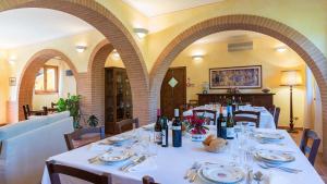 a dining room with tables with wine bottles and glasses at PODERINA DEI POGGI 12, Emma Villas in Castiglione del Lago