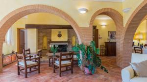 a living room with arches and a table and chairs at PODERINA DEI POGGI 12, Emma Villas in Castiglione del Lago