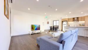 a living room with a blue couch and a kitchen at Evergreen 3B Home by Goodlive in Clyde