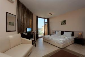a bedroom with a bed and a desk and a couch at Vemara Club Villas in Byala +18 photos