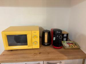 a yellow microwave sitting on top of a wooden table at Calm guest house in Clerval