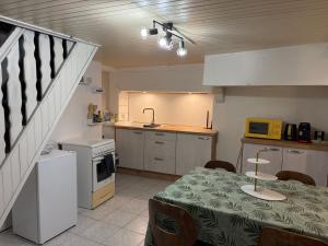 a kitchen with a table and a kitchen with a table and chairs at Calm guest house in Clerval