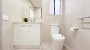 a white bathroom with a toilet and a sink at Evergreen 3B Home by Goodlive in Clyde +36 photos