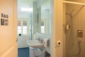 a bathroom with a sink and a shower at Leissigen Youth Hostel in Leissigen +33 photos