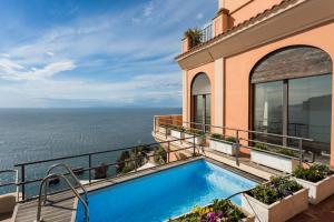 a swimming pool on the balcony of a house at Villa Margi in Vico Equense