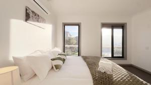 a white bedroom with a large bed with windows at Evergreen 3B Home by Goodlive in Clyde