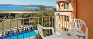 a balcony with two chairs and a swimming pool at Vemara Club Villas in Byala