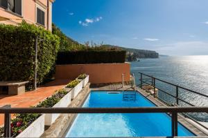 a swimming pool on a balcony overlooking the water at Villa Margi in Vico Equense
