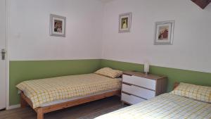 two beds in a room with green and white walls at Appartement Privé, Camping La Pointe in Châteaulin