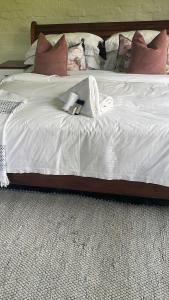 a white bed with a stuffed animal on it at Indaba tree lodge in Bulawayo