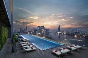 
a row of benches sitting on top of a pier at Avani Plus Riverside Bangkok Hotel -SHA Plus Certified in Bangkok
