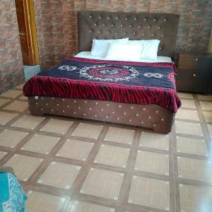 ein Bett mit einer schwarz-roten Decke auf dem Boden in der Unterkunft River Breeze Hotel in Mingora + 1 Foto
