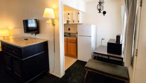 a kitchen with a refrigerator and a table with a chair at Magnuson Hotel Sierra Vista in Sierra Vista
