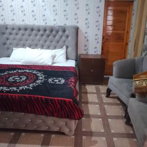 ein Schlafzimmer mit einem Bett, einer Couch und einem Stuhl in der Unterkunft River Breeze Hotel in Mingora