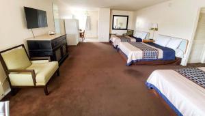 a hotel room with two beds and a chair at Magnuson Hotel Sierra Vista in Sierra Vista