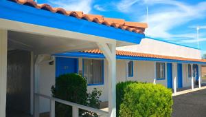 a house with a blue roof and some bushes at Magnuson Hotel Sierra Vista in Sierra Vista